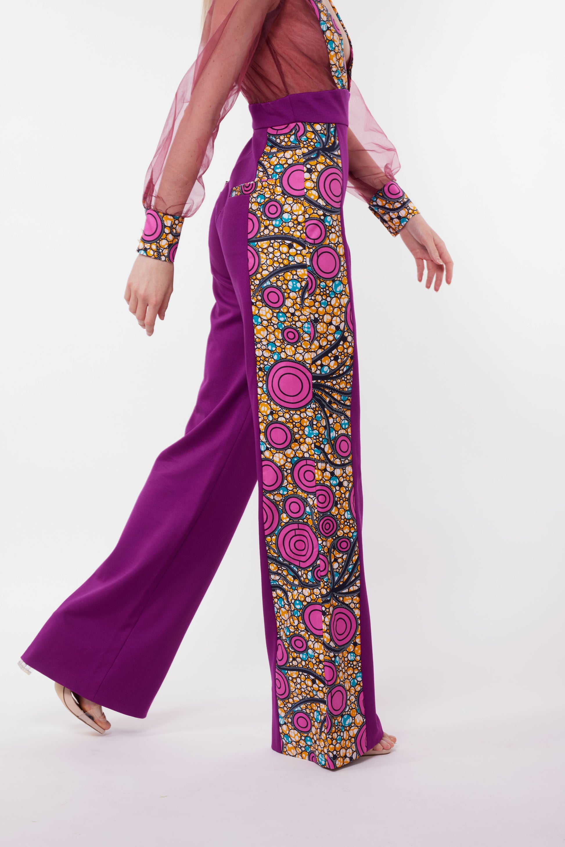Vue latérale de la combinaison composée d'un pantalon violet taille haute avec un panneau latéral en tissu wax coloré. 